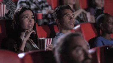Sinemada korku filmi izleyen melez bir çift.
