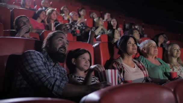 Gemengd ras familie genieten van de film in de bioscoop — Stockvideo