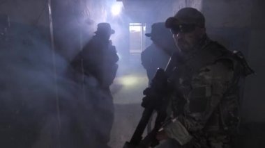 Üç deneyimli dövüşçü dumanlı binaya saldırıyor.