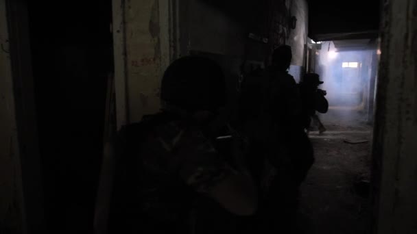 Grupo de soldados moviéndose a lo largo de oscuro corredor ahumado — Vídeo de stock
