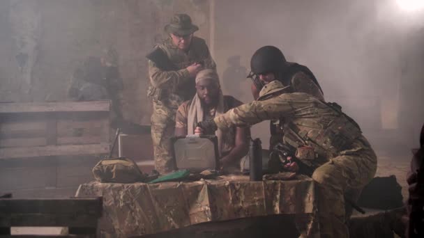 Escuadrón de soldados trabajando en portátil en base ahumada — Vídeos de Stock
