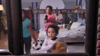 Komik melez kızlar pencerenin önünde oynaşıyor.