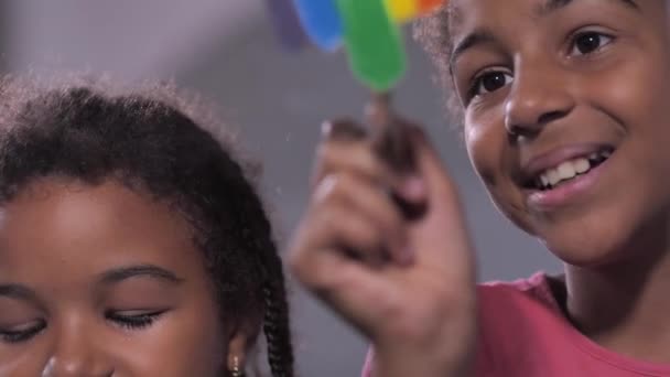 Lindas chicas sonrientes pintando color arco iris en vidrio — Vídeos de Stock