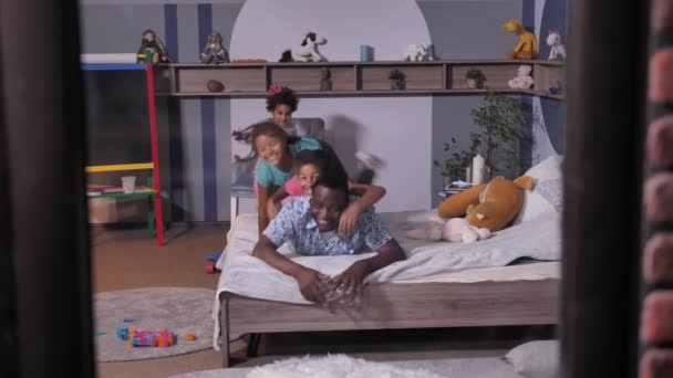 Zwarte vader met dochters maken familie hoop op bed — Stockvideo