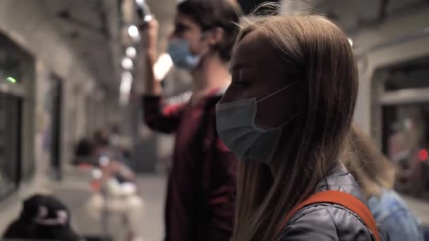 Mujer con máscara protectora cabalgando en tren subterráneo — Vídeos de Stock