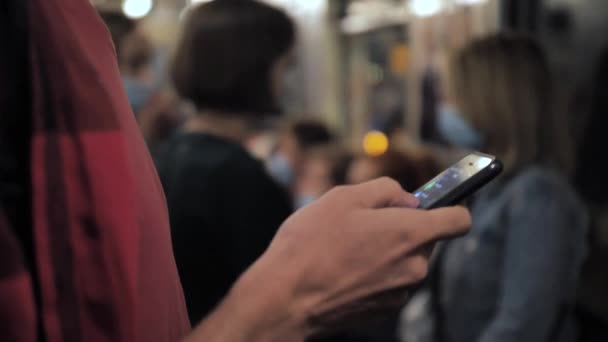 Druk op mobiele telefoon gemaskerde man rijden in metro trein — Stockvideo