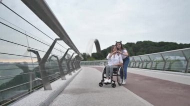Engelli anne ve elleriyle kalbini gösteren bir kız.