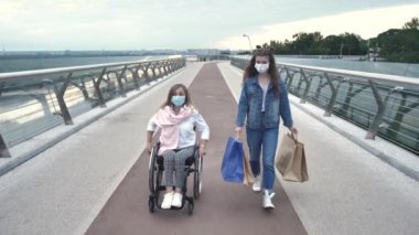 Alışveriş sonrası maskeli kadın ve kız
