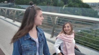 Mutlu engelli kadın kızıyla yürürken konuşuyor.
