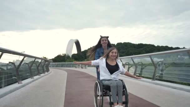 Радостная мама с девушкой, наслаждающаяся поездкой на инвалидном кресле — стоковое видео