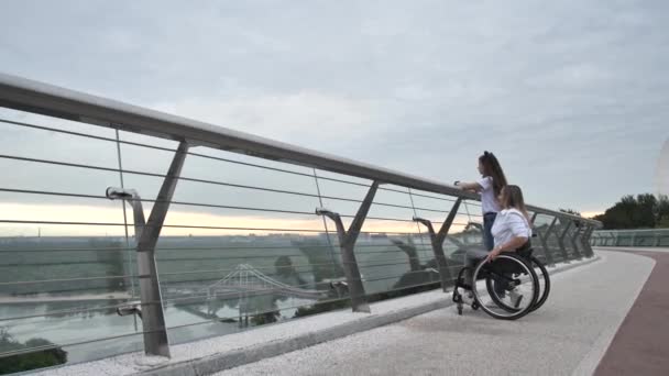 Disabled mom with girl admiring view from bridge — Stock Video