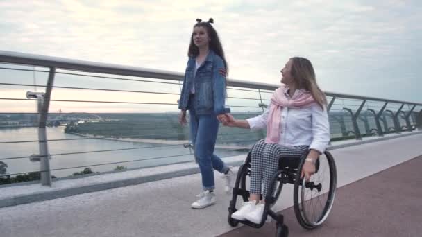 Nöjd mamma på rullstol under promenaden med dotter — Stockvideo