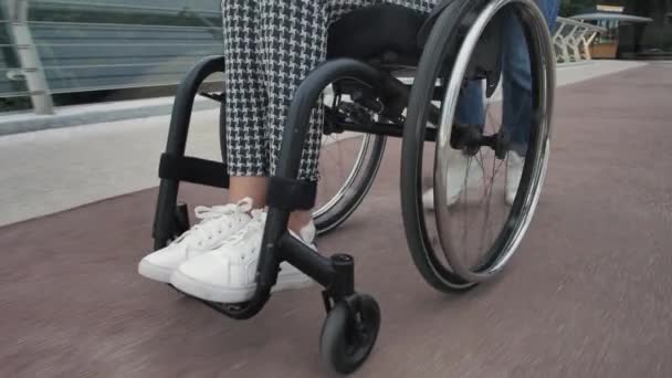 Езда на инвалидной коляске, мама с дочерью на открытом воздухе — стоковое видео
