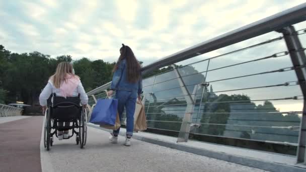 Disabled mom with daughter walking after shopping — Stock Video