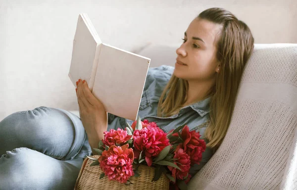 Chica Sofá Con Peonías Rojas Leyendo Libro —  Fotos de Stock