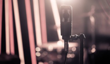 Mikrofon davul ile stüdyo ya da konser salonu yakın çekim, kayıt arka plan odağını ayarlayın. Güzel renkli fenerler arka plan bulanık. Vintage tarzı müzik konsepti.