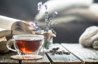 çay iç ahşap zemin üzerine bir kitap lavanta çiçekler şeffaf bir vazoda ile