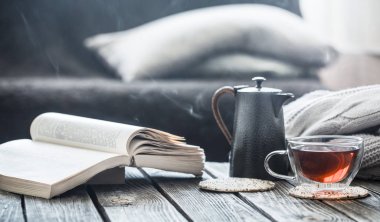 Natürmort kitap ve ahşap bir masaya oturma odasında çay, coziness ve iç kavramı
