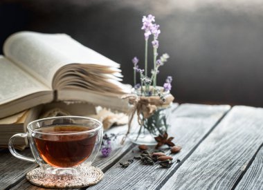 çay iç ahşap zemin üzerine bir kitap lavanta çiçekler şeffaf bir vazoda ile