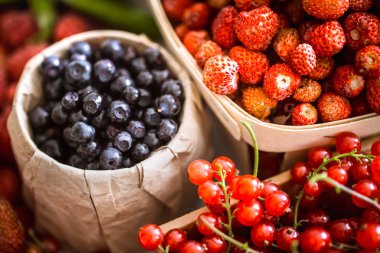 bir kavanoza bir arka planda farklı meyve taze yaban mersini, sağlıklı bir diyet ve vitaminler makro kavramı vurdu