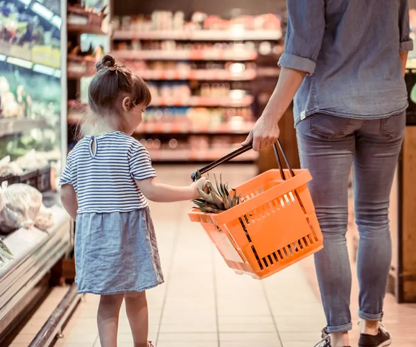 Mom and daughter are shopping at the supermarket, the concept of family relationships and healthy eating