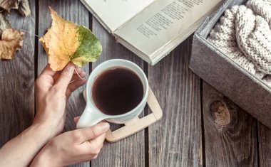 Ahşap arka plan üzerinde elinde kahve, ev konfor ve coziness kavramı ile kız
