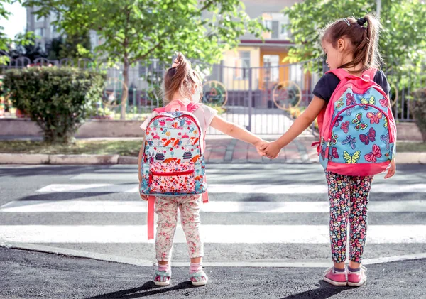 子供たちが行く学校 ランドセルと幸せな学生と一緒に 手を繋いでいるクロス ロード 女の子と教育の概念 — ストック写真