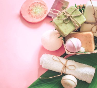 Tropikal spa kompozisyon sabun pembe bir arka plan, rahatlama ve vücut bakım kavramı tuz bombaları ile