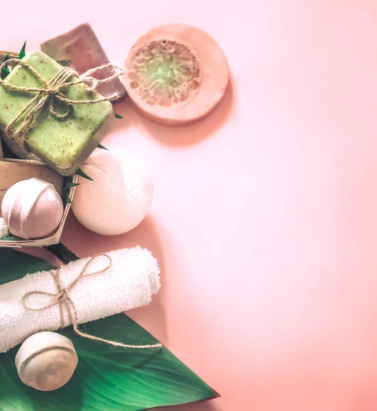 Tropikal spa kompozisyon sabun pembe bir arka plan, rahatlama ve vücut bakım kavramı tuz bombaları ile
