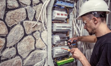Erkek bir elektrikçi elektrik bağlantı kablosunu ile geçiş panosu çalışır, ekipman bağlar araçları, karmaşık iş kavramı, metin için yer