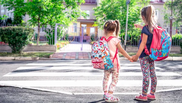 子供ランドセルと幸せな学生 学校に行くし 教育の女の子とのテキストのためのスペースの概念道路を横断 一緒に手を繋いで — ストック写真