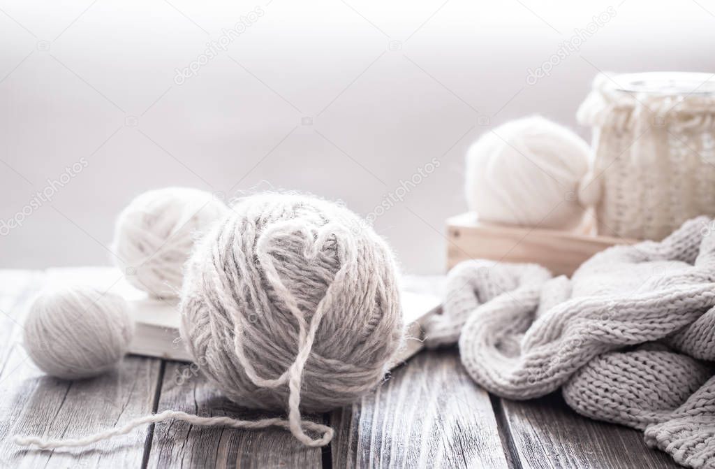 home hobbies, cozy knitted sweaters with a ball of yarn in the living room on a wooden background