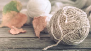 Ev yapımı hobi, örgü konuları dışarı atılmıştır kalp ve ahşap zemin, sonbahar yaprakları ile yer metin makro çekim için