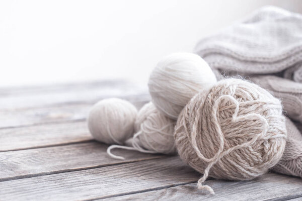 homemade hobby, knitting threads with a laid out heart in the middle on a wooden background, space for text macro shooting