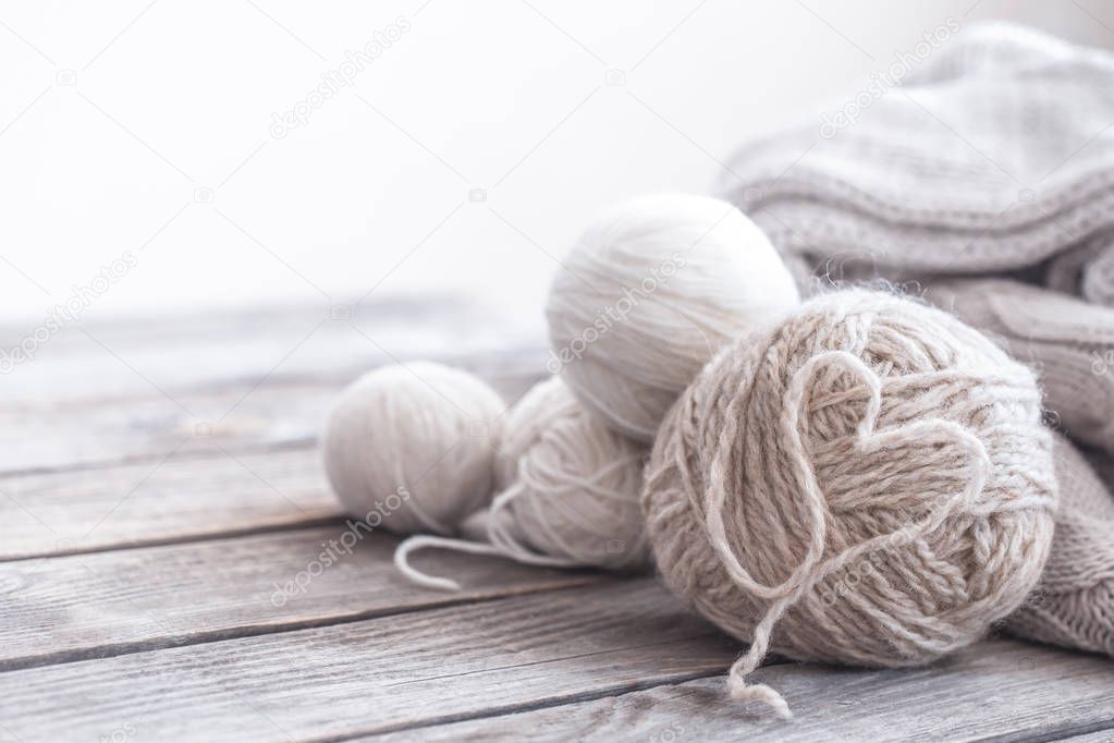 homemade hobby, knitting threads with a laid out heart in the middle on a wooden background, space for text macro shooting