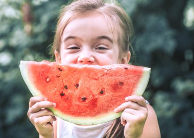 Gıda ve sağlık kavramı küçük küçük sevimli kız bir parça karpuz ve gülümseyen, holding