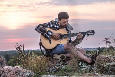 genç gün batımında, müzik gitar açık havada ile adam ve kavram seyahat