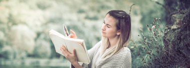 Genç bir kız bir kazaklı bir arka plan boş zaman kavramını ve bir hobi, doğanın bir kitap okur