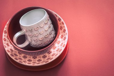 Güzel yemek kapları ile kırmızı renkli bir arka plan olarak el yapımı bir fincan