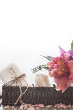 Tropikal bir orkide, vücut bakım anlayışı ile hafif bir arka plan üzerinde bir hasır spa maddelerinde standı