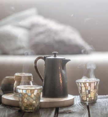 Natürmort üzerinden küçük bir su ısıtıcısı ve güzel bir cam, ev konfor kavramı ahşap bir zemin üzerine ev iç