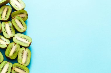 Kivi mavi arka plan, pop sanat üzerinde taze yarısı. Üstten görünüm, yakın çekim, yaratıcı kavramı