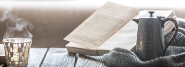 Natürmort üzerinden küçük bir su ısıtıcısı ve güzel bir cam, ev konfor kavramı ahşap bir zemin üzerine ev iç