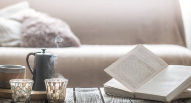 Natürmort üzerinden küçük bir su ısıtıcısı ve güzel bir cam, ev konfor kavramı ahşap bir zemin üzerine ev iç