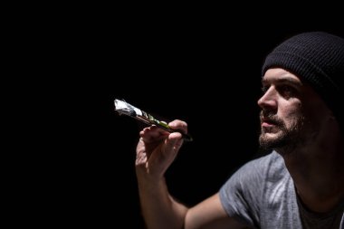 bir adam siyah bir arka plan iş boyama kavramı üzerinde beyaz boya ile bir fırça boyar, metin için bir yer, nesneyi kapatın