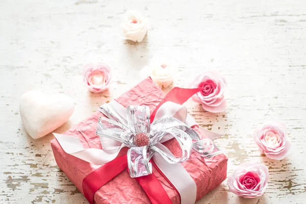 情人节和母亲节概念 红色礼品盒与弓和玫瑰在轻的木背景 — 图库照片