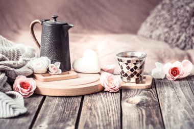 Sevgililer günü ya da anneler günü, çay ile şenlikli bir natürmort ve evde oturma odasında ahşap bir masa üzerinde bir çaydanlık için kavram