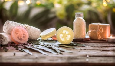 Spa beyaz havlu ve deniz tuzu ile el yapımı sabun, tropikal bileşimi yaprakları ile bir mum, ahşap arka plan metin için yer, Spa ve rahatlama için vücut kavramı ile