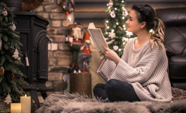 Kız şömine, eve geri kalan kavramı yakın rahat bir ev atmosferde bir kitap okuma
