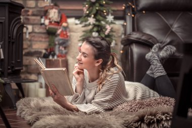 Kız şömine, eve geri kalan kavramı yakın rahat bir ev atmosferde bir kitap okuma